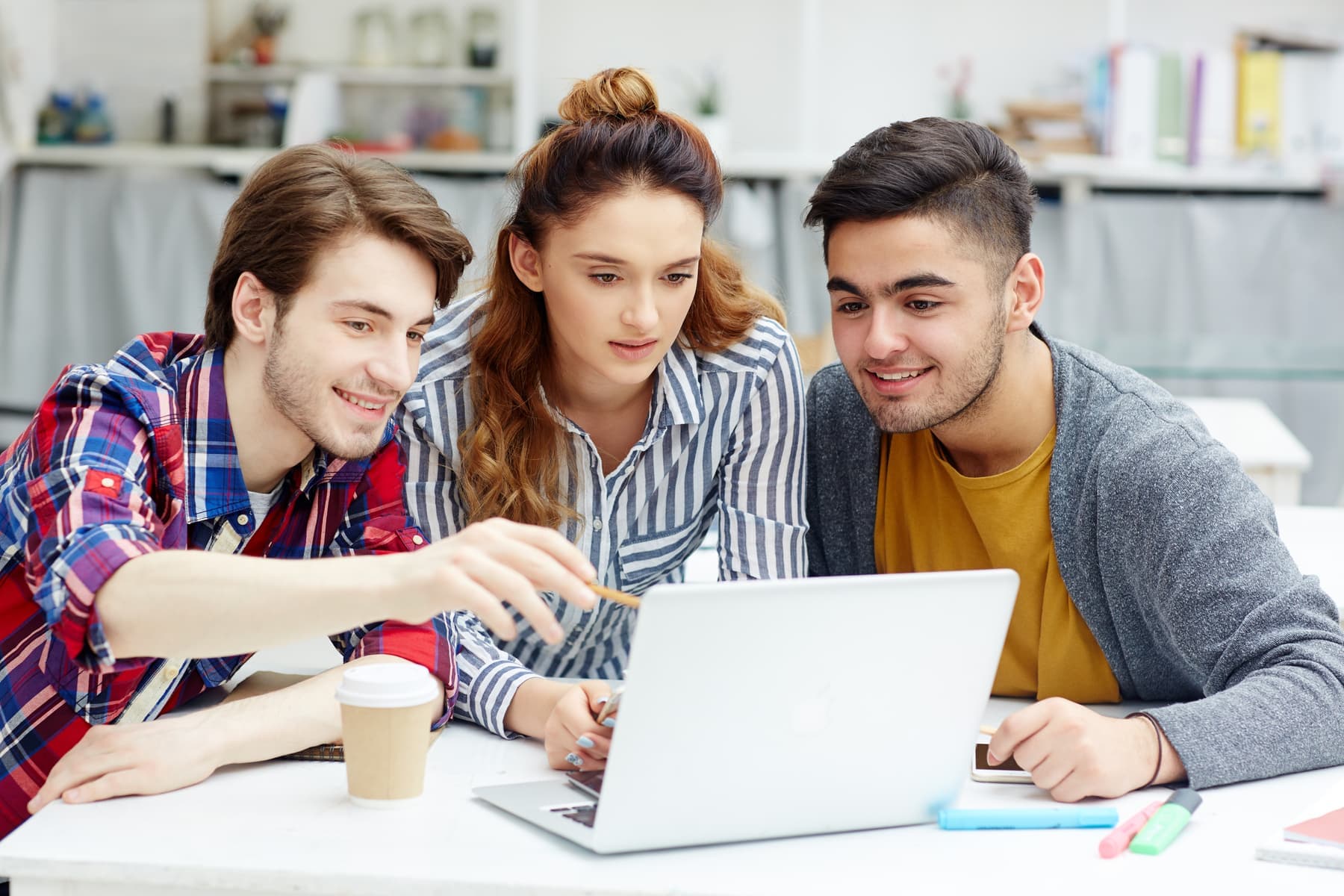 Students collaborating around a laptop